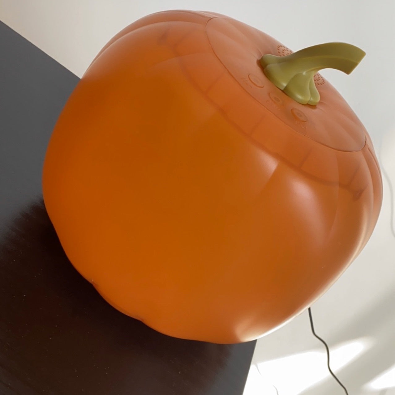 Talking and Singing Pumpkin Projectors with a green stem on a neutral background